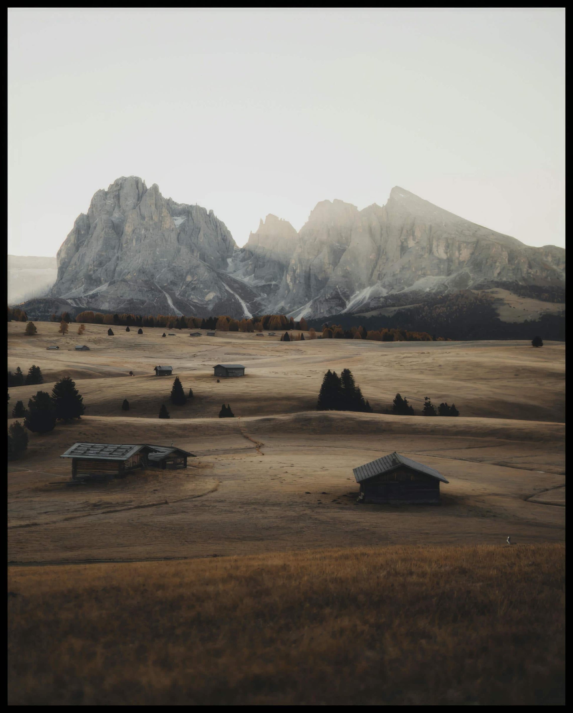 Ein Leinwandbild von einer Alm in den Dolomiten bei Sonnenaufgang.