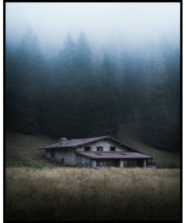 Ein Poster von einer einsamen Hütte im Nebel, umgeben von hohen Bäumen.