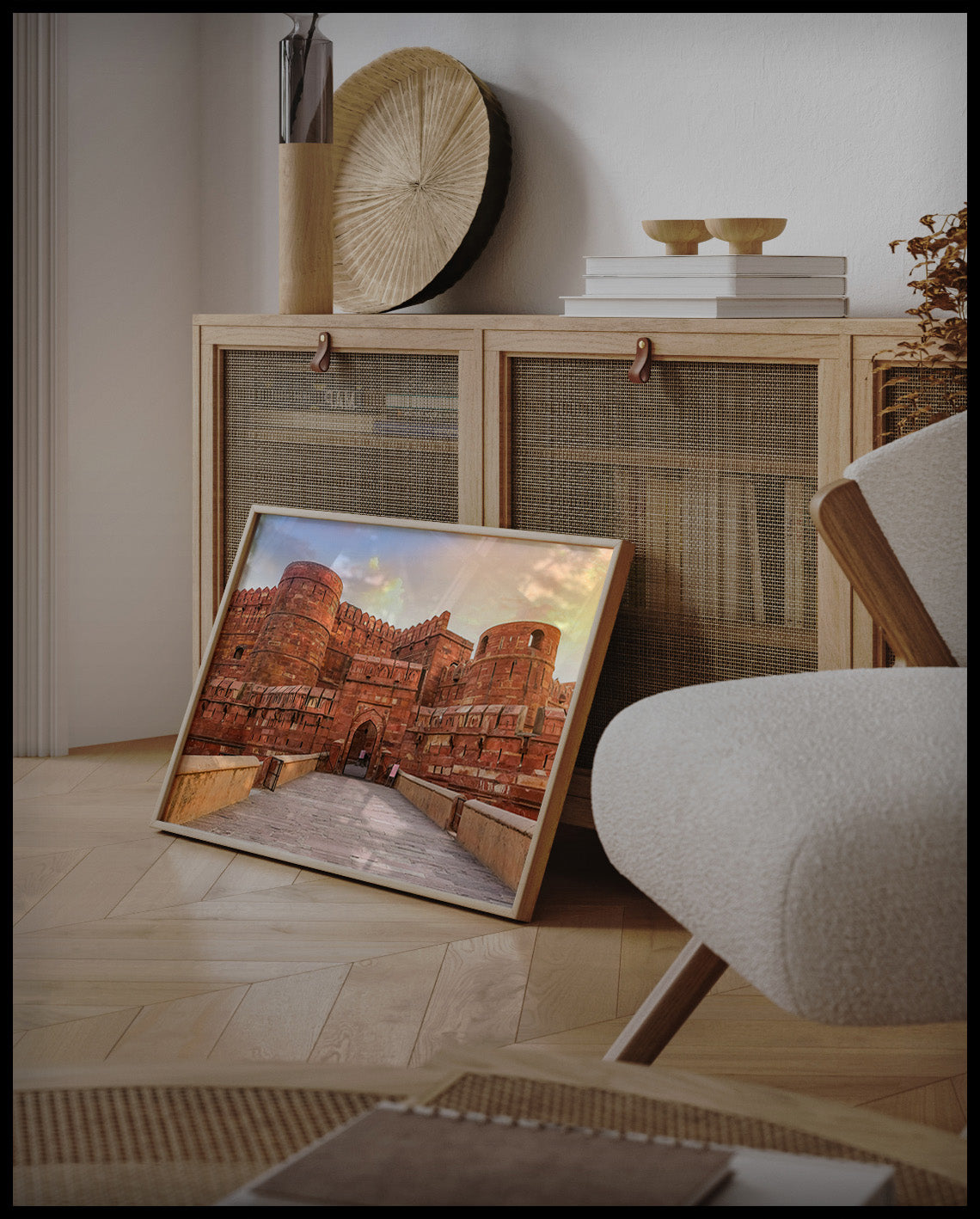 Ein gerahmtes Poster vom Agra Fort in Indien bei Sonnenuntergang, an einer Holzkommode angelehnt und stehend auf dem Holzboden