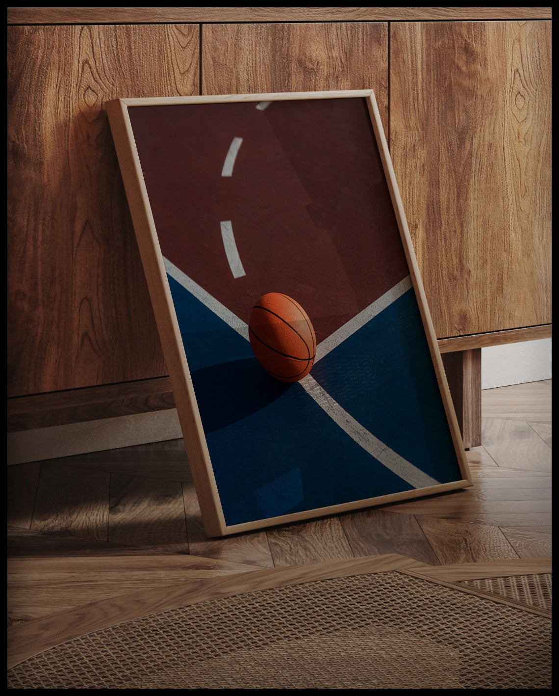 Ein gerahmtes Poster von einem Basketball auf einem Basketballplatz mit roten und blauen Feldern, an einer Holzkommode angelehnt und stehend auf dem Holzboden