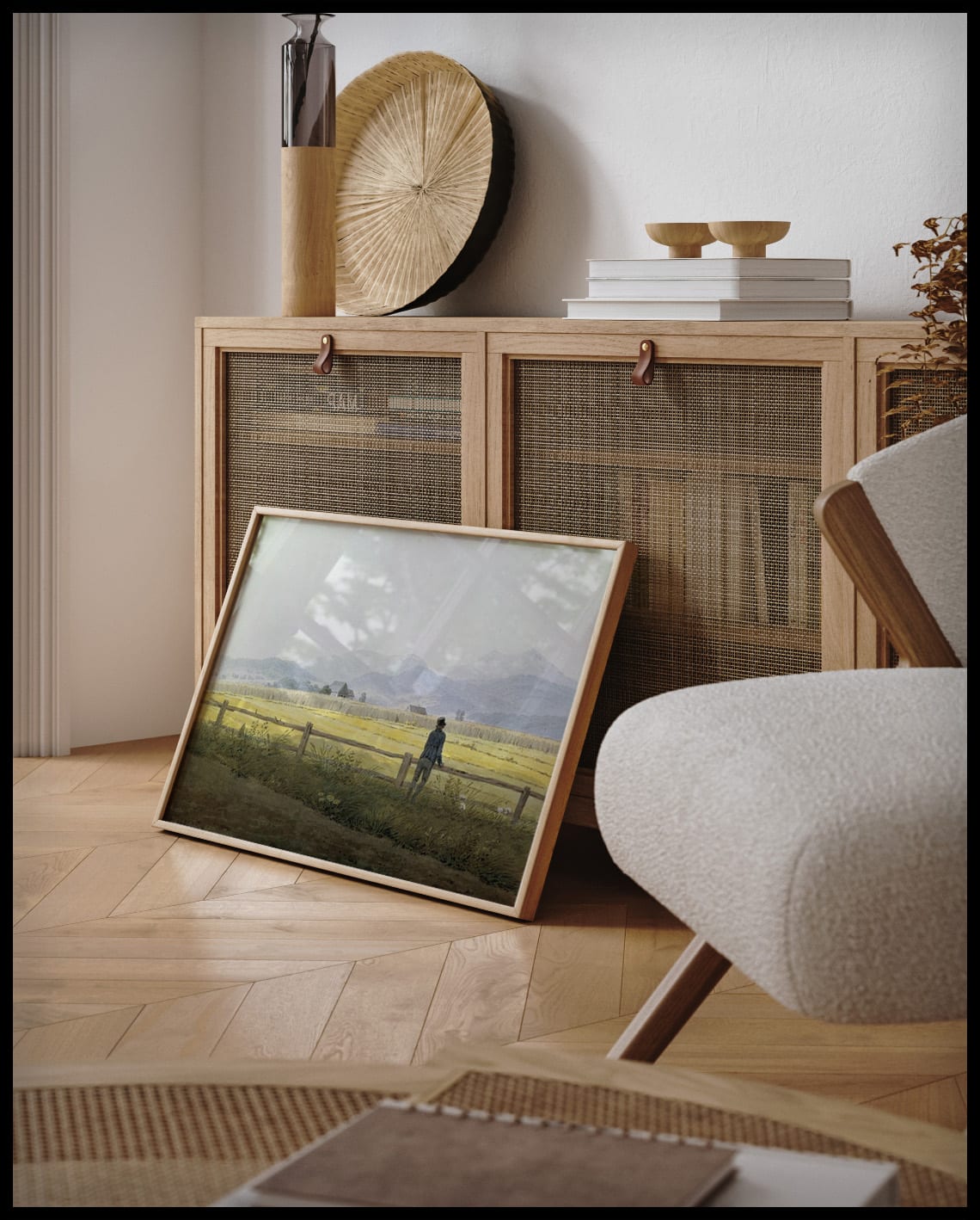 Ein gerahmter Kunstdruck von einem Feld, an einer Holzkommode angelehnt und stehend auf dem Holzboden