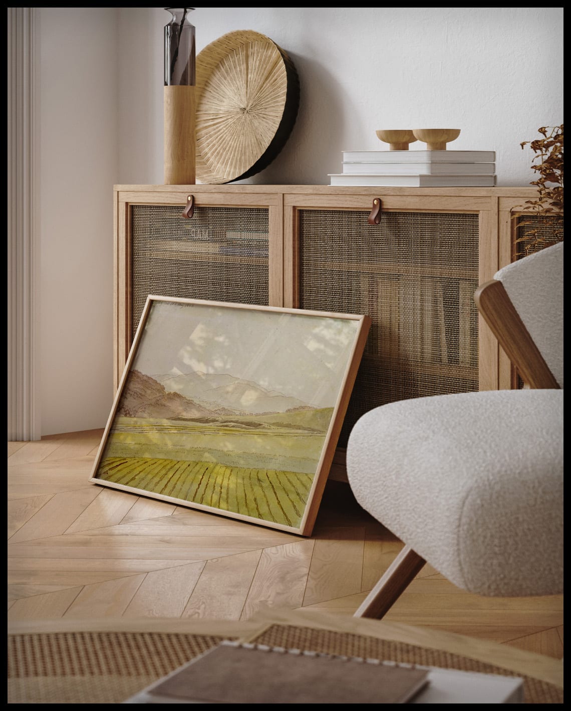 Ein gerahmter Kunstdruck von einem Feld und bewaldeten Bergen im Hintergrund, an einer Holzkommode angelehnt und stehend auf dem Holzboden