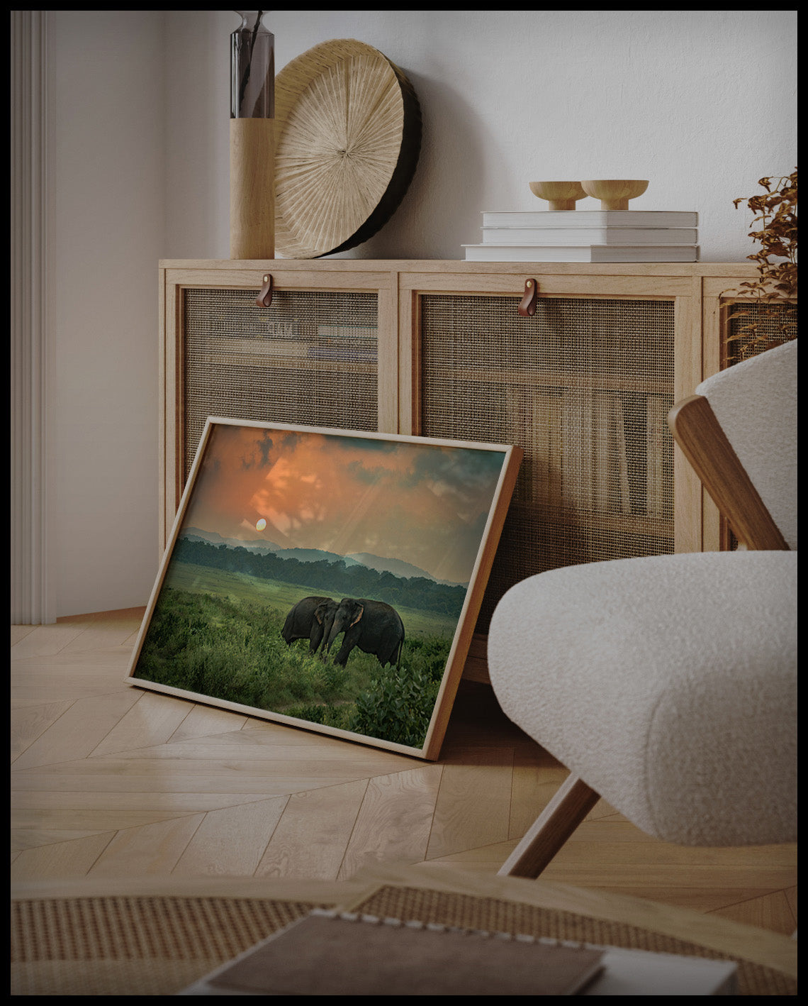 Ein gerahmtes Poster von zwei Elefanten bei Sonnenuntergang in Afrika, an einer Holzkommode angelehnt und stehend auf dem Holzboden