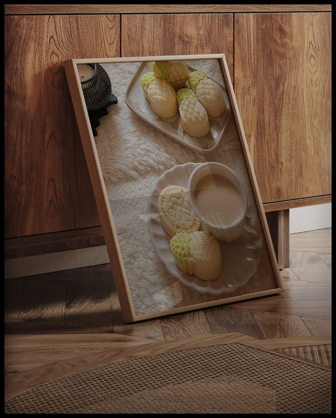 Ein gerahmtes Poster von einer Tasse Kaffee und Ananas-geformten Keksen auf einem Teller, arrangiert auf einem weichen, flauschigen Untergrund, an einer Holzkommode angelehnt und stehend auf dem Holzboden