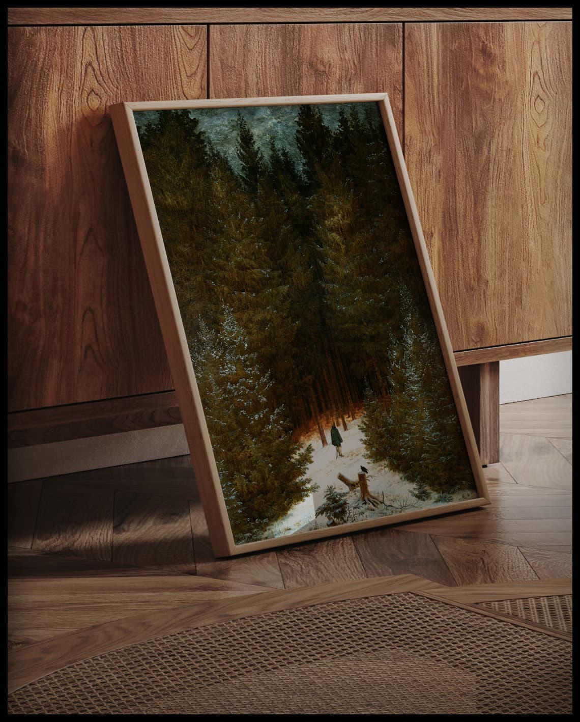 Ein gerahmter Kunstdruck eines winterlichen Waldweges mit einem Jäger, an einer Holzkommode angelehnt und stehend auf dem Holzboden