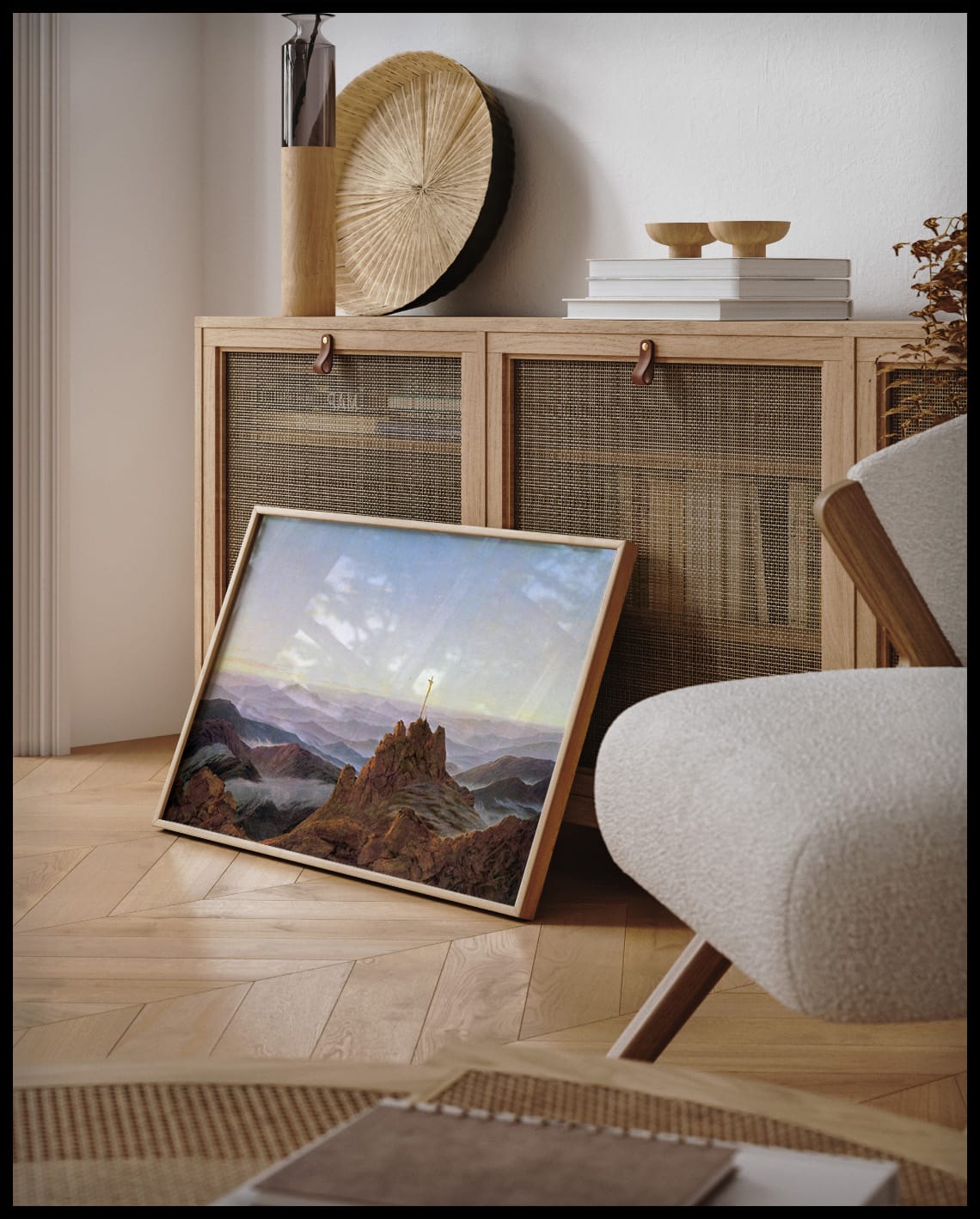 Ein gerahmter Kunstdruck von einem Gipfelkreuz und einem weiten Blick in das Riesengebirge, an einer Holzkommode angelehnt und stehend auf dem Holzboden