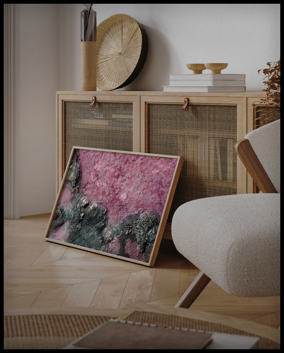 Ein gerahmtes Poster von rosa Salz und dunklem Gestein, an einer Holzkommode angelehnt und stehend auf dem Holzboden