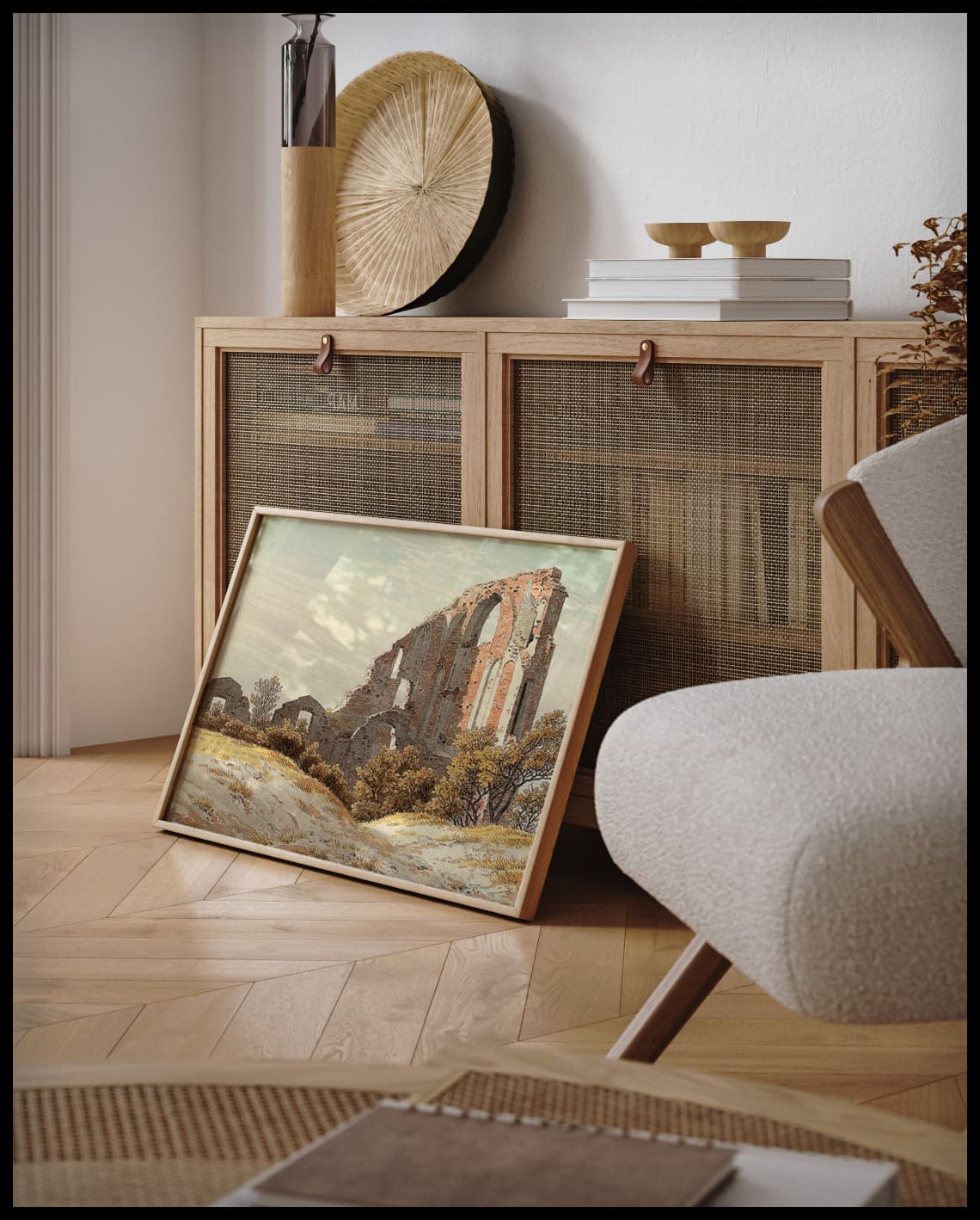 Ein gerahmter Kunstdruck von einer alten Ruine hinter einem grasbewachsenen Hügel, an einer Holzkommode angelehnt und stehend auf dem Holzboden
