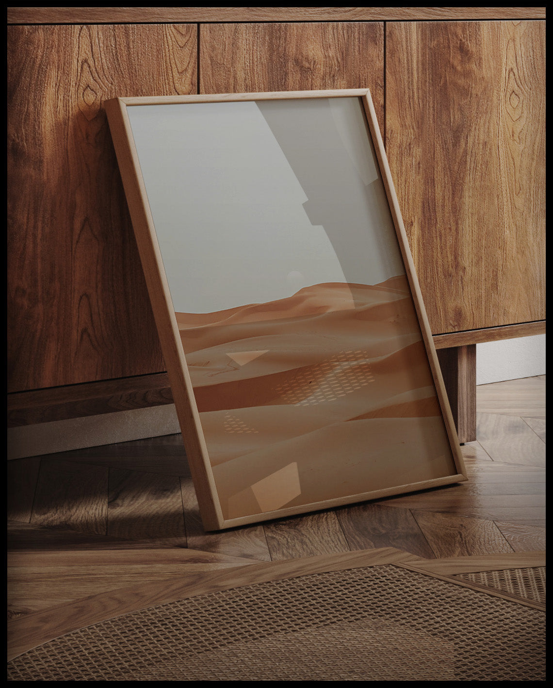 Ein gerahmtes Poster von den weichen, geschwungenen Sanddünen der Sahara, an einer Holzkommode angelehnt und stehend auf dem Holzboden