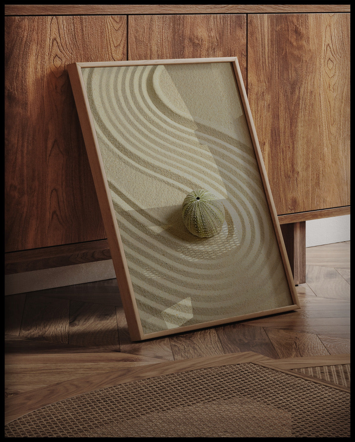 Ein gerahmtes Poster von einem Seeigel der auf feinem Sand liegt, an einer Holzkommode angelehnt und stehend auf dem Holzboden