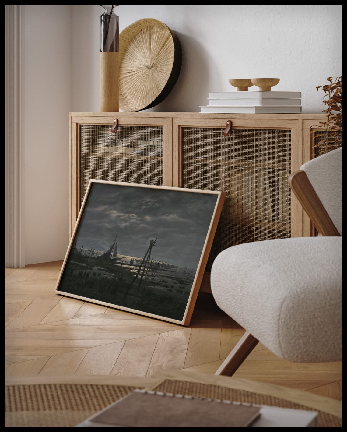 Ein gerahmter Kunstdruck von einem sumpfigen Strand mit einem Segelboot in der Nähe, an einer Holzkommode angelehnt und stehend auf dem Holzboden