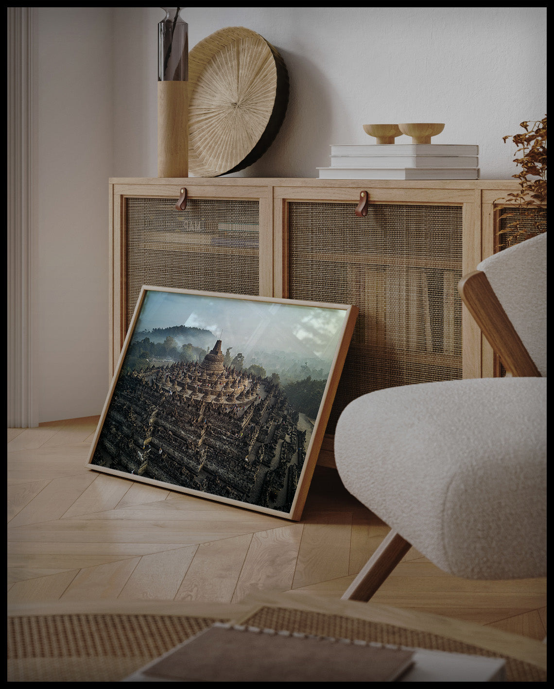 Ein gerahmtes Poster von einer steinernen, mehrstöckigen Tempelanlage, an einer Holzkommode angelehnt und stehend auf dem Holzboden