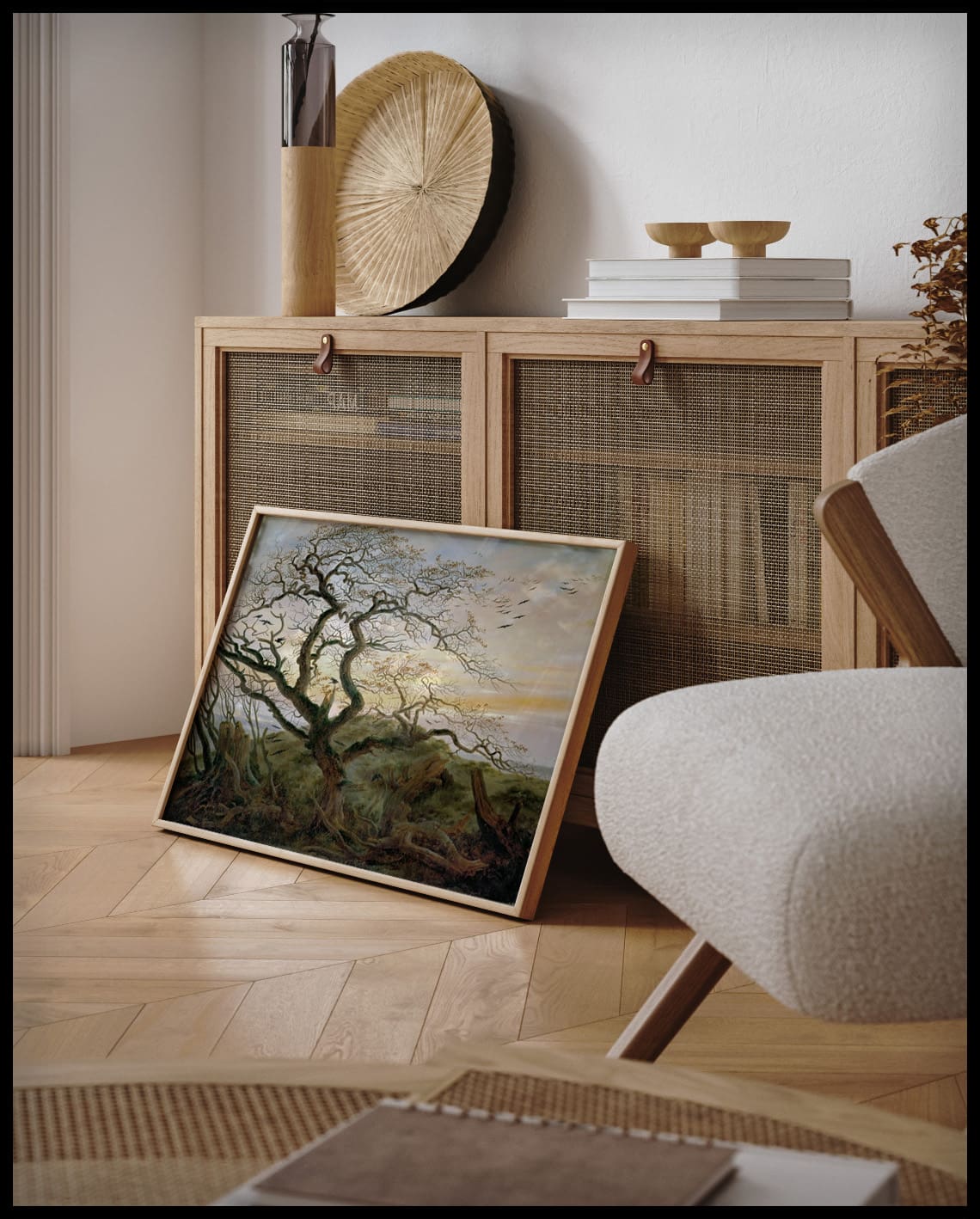 Ein gerahmter Kunstdruck von einem kahlen Baum mit vielen Krähen, an einer Holzkommode angelehnt und stehend auf dem Holzboden