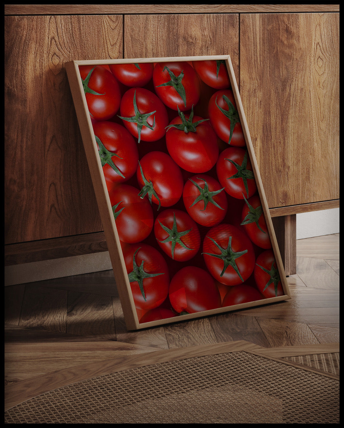 Ein gerahmtes Poster einer Nahaufnahme von mehreren Tomaten, an einer Holzkommode angelehnt und stehend auf dem Holzboden