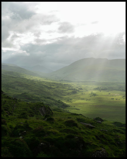 Ein Poster von einer grünen Landschaft in Irland mit Sonnenstrahlen.