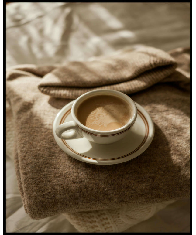 Ein Poster von einer Tasse Kaffee auf einem gemütlichen, beigen Pullover.