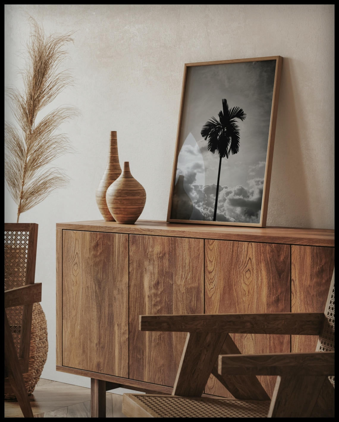 Ein gerahmtes Poster von einer einsamen Palme vor bewölktem Himmel in Schwarz-Weiß, auf einer Holzkommode an die Wand angelehnt