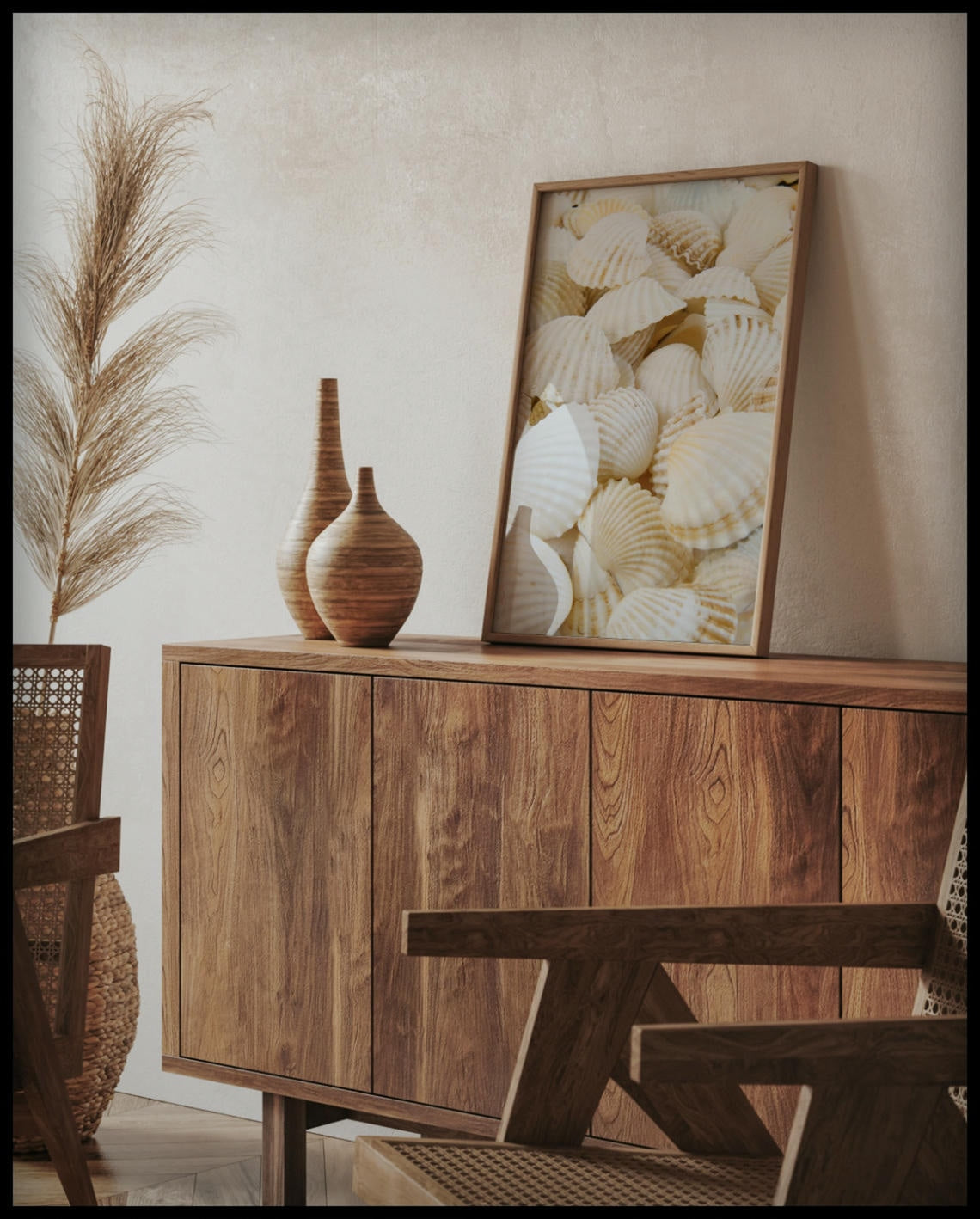 Ein gerahmtes Poster von weißen Muscheln, auf einer Holzkommode an die Wand angelehnt