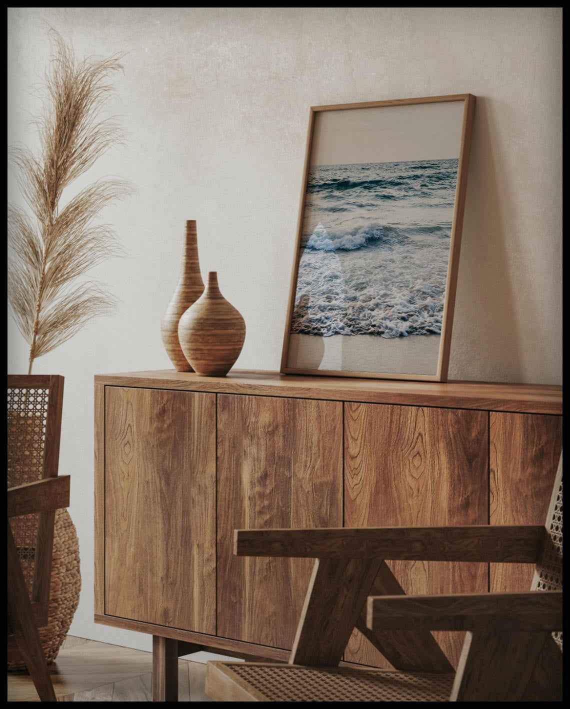 Ein gerahmtes Poster von schaumigen Wellen am Strand, auf einer Holzkommode an die Wand angelehnt