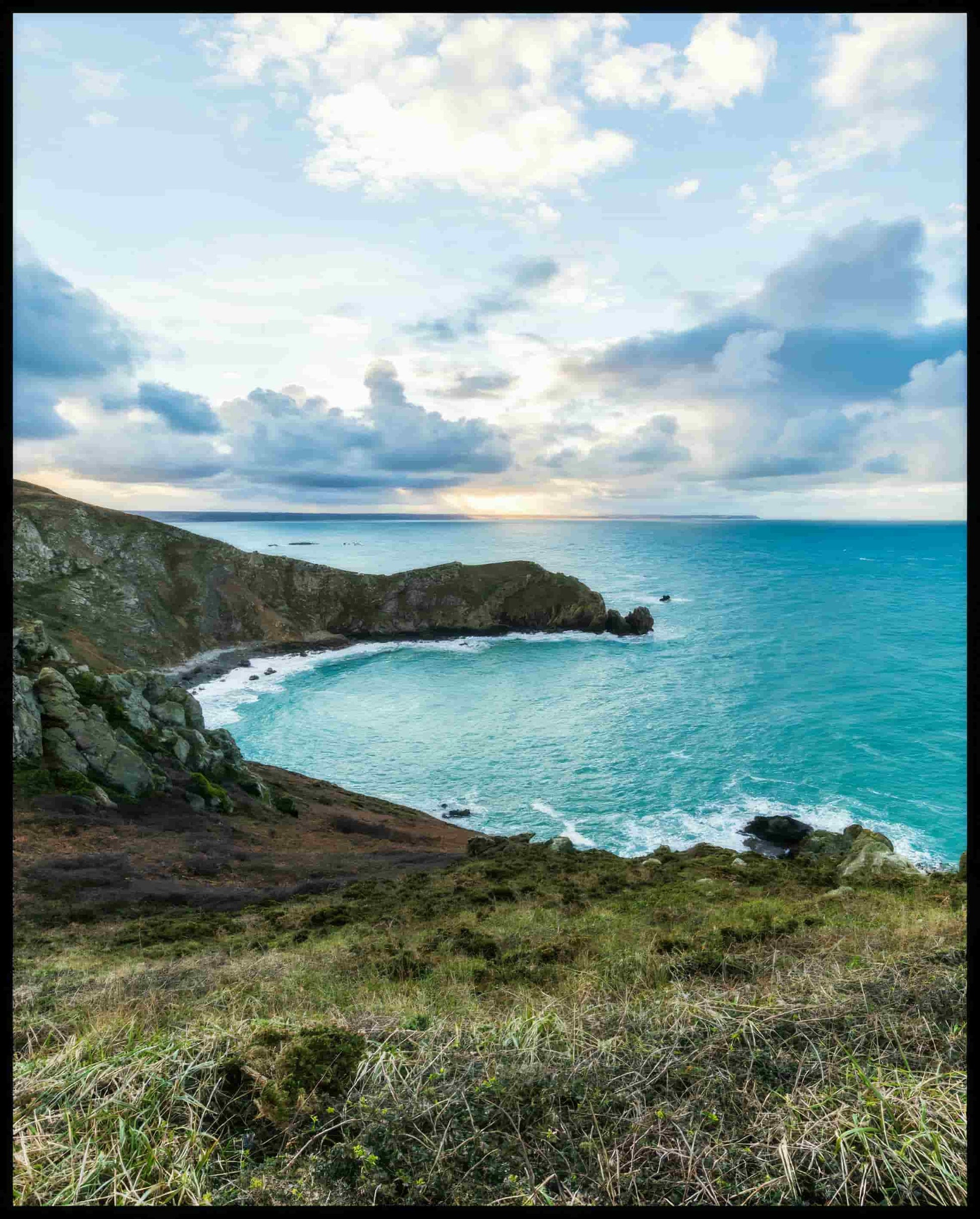 Ein Poster vom Blick einer Bucht über das blaue Meer.