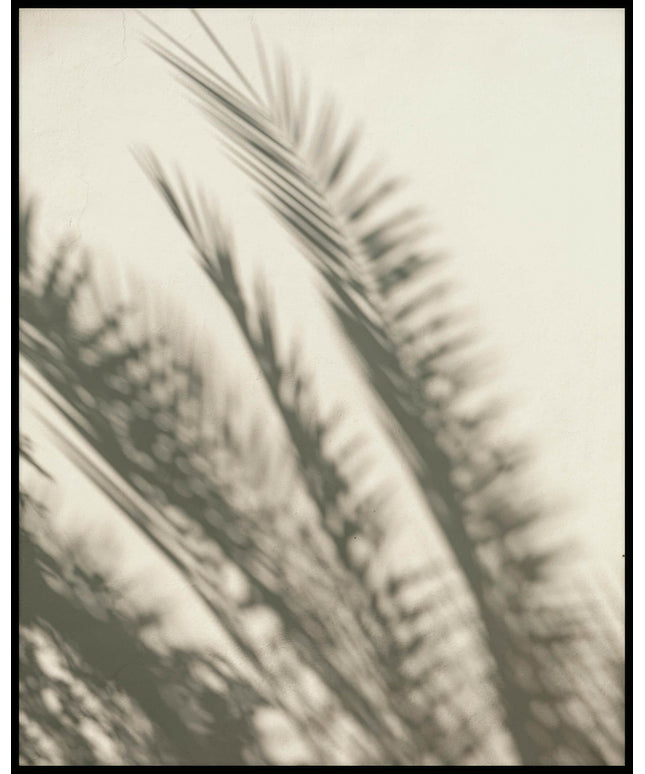 Ein Poster vom Schatten mehrerer Palmenblätter auf einer beigen Wand.