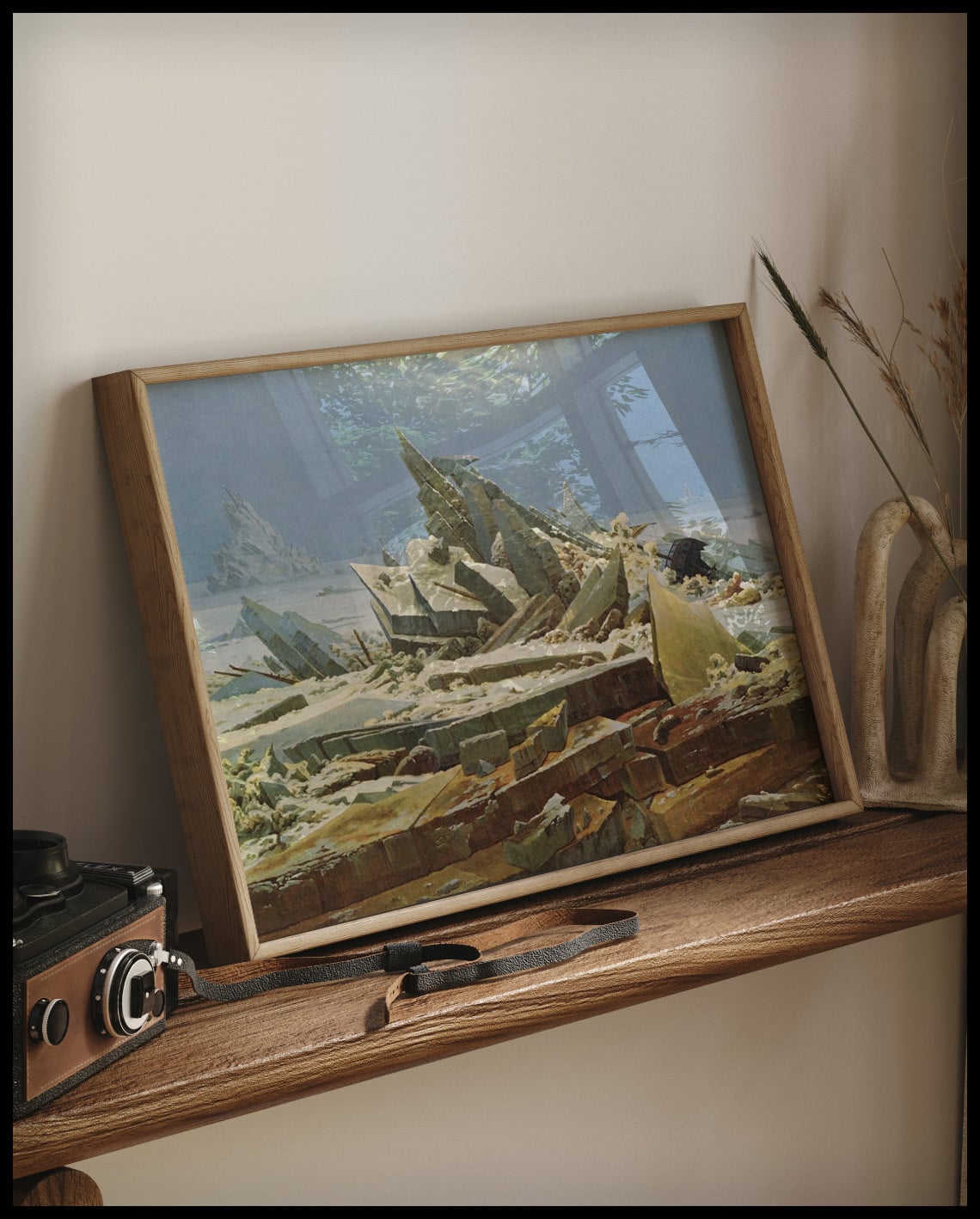 Ein gerahmter Kunstdruck von einer arktischen Landschaft mit sich auftürmenden Eisschollen, auf einem Holzregal an die Wand angelehnt
