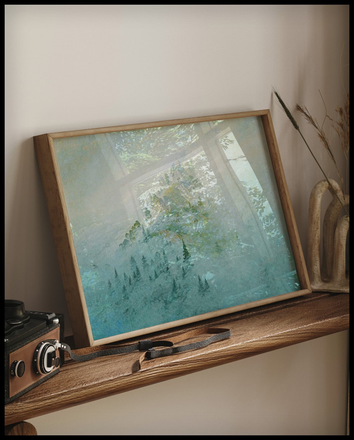 Ein gerahmter Kunstdruck vom Blick auf einen nebligen Berggipfel mit Bäumen am Bergfuß, auf einem Holzregal an die Wand angelehnt