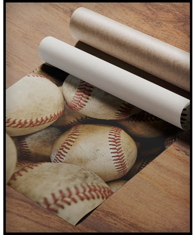 Ein Poster von mehreren alten Baseballbällen mit abgenutzten Nähten, gerollt auf einer Holzoberfläche liegend