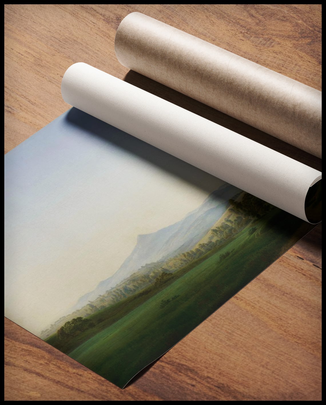 Ein Kunstdruck von einer weiten Landschaft mit hügeligen Wiesen und einigen Bäumen, gerollt auf einer Holzoberfläche liegend