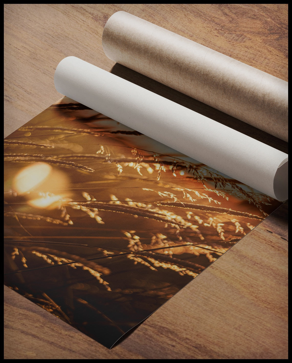 Ein Poster von Getreidehalmen im Sonnenuntergang, gerollt auf einer Holzoberfläche liegend