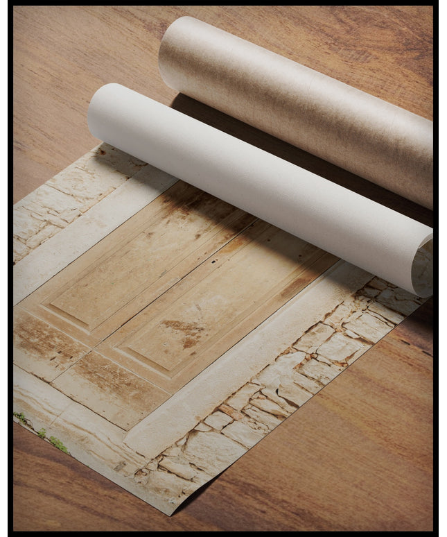 Ein Poster von einer alten, verwitterten Holztür in einer Steinmauer, gerollt auf einer Holzoberfläche liegend