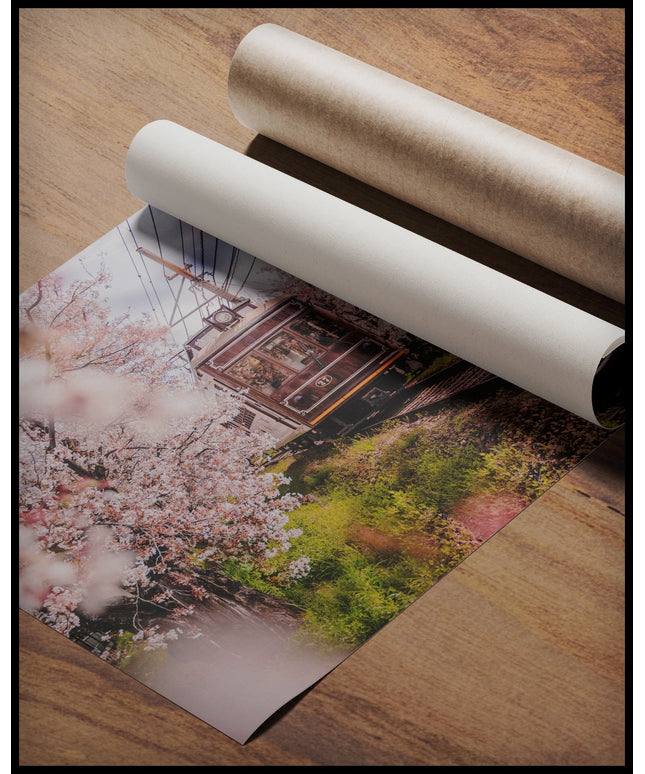 Ein Poster von einer alten Straßenbahn, die durch blühende Kirschbäume fährt, gerollt auf einer Holzoberfläche liegend