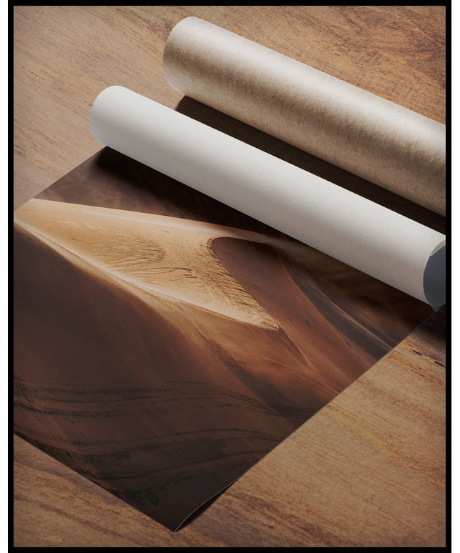 Ein Poster von einer Sanddüne in der Wüste, gerollt auf einer Holzoberfläche liegend