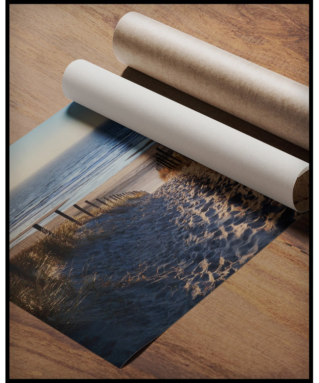 Ein Poster von Fußspuren im Sand auf einem Sandweg zum Strand, gerollt auf einer Holzoberfläche liegend