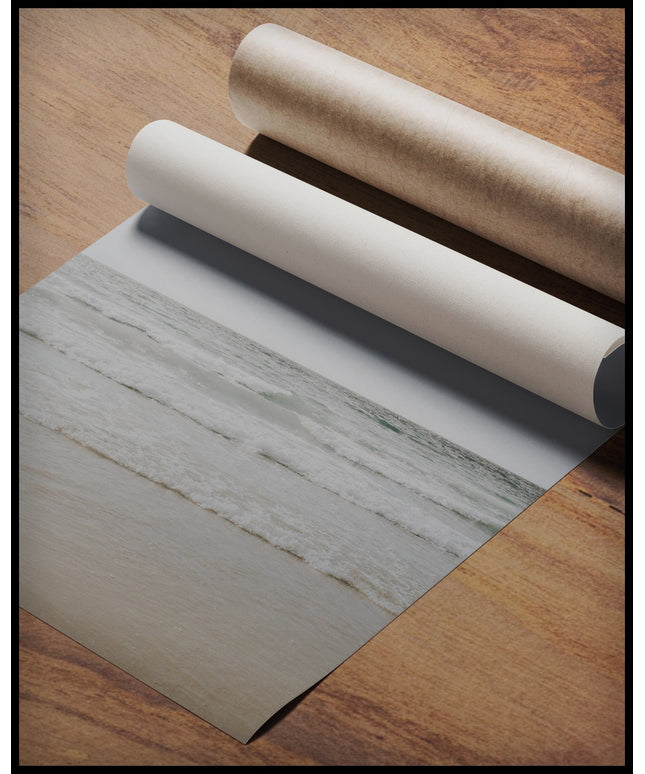 Ein Poster von einem Meeresblick auf leichte Wellen, gerollt auf einer Holzoberfläche liegend