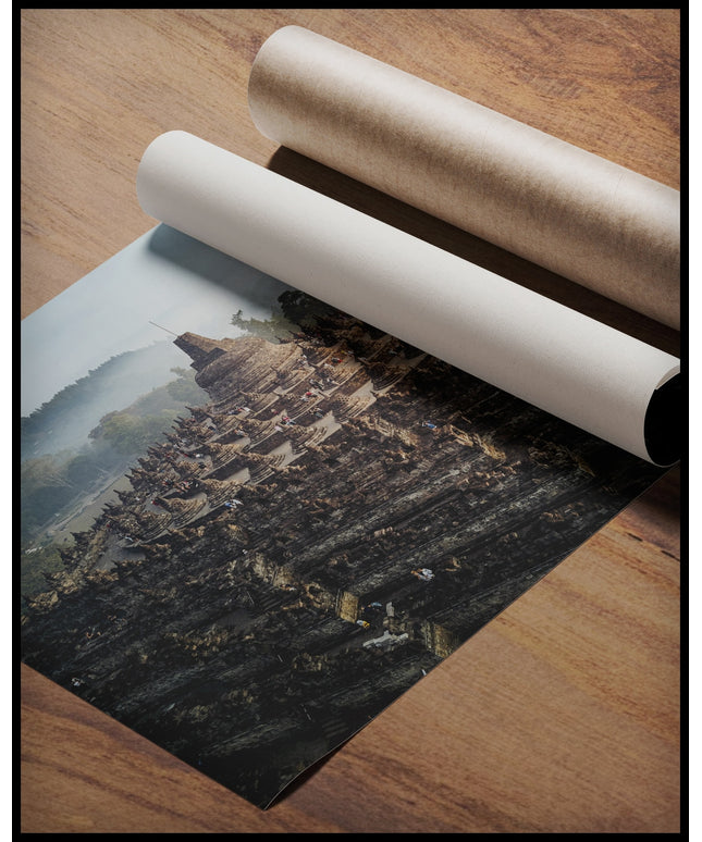 Ein Poster von einer steinernen, mehrstöckigen Tempelanlage, gerollt auf einer Holzoberfläche liegend