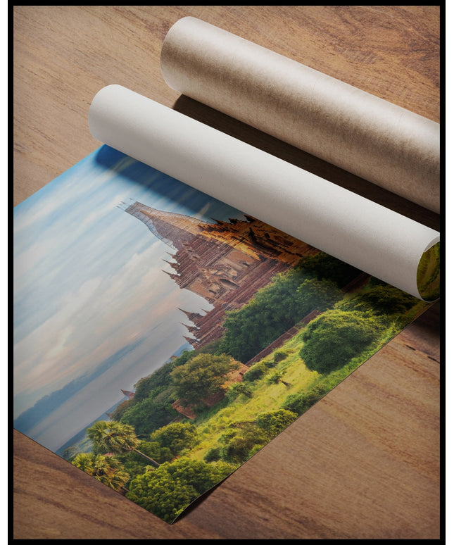Ein Poster von einem hohen Tempel inmitten einer bewachsenen Landschaft, gerollt auf einer Holzoberfläche liegend