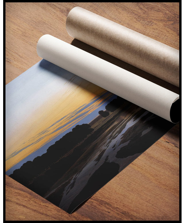 Ein Kunstdruck von einem Überschwemmungsgebiet mit Sand- und Schlamminseln, gerollt auf einer Holzoberfläche liegend