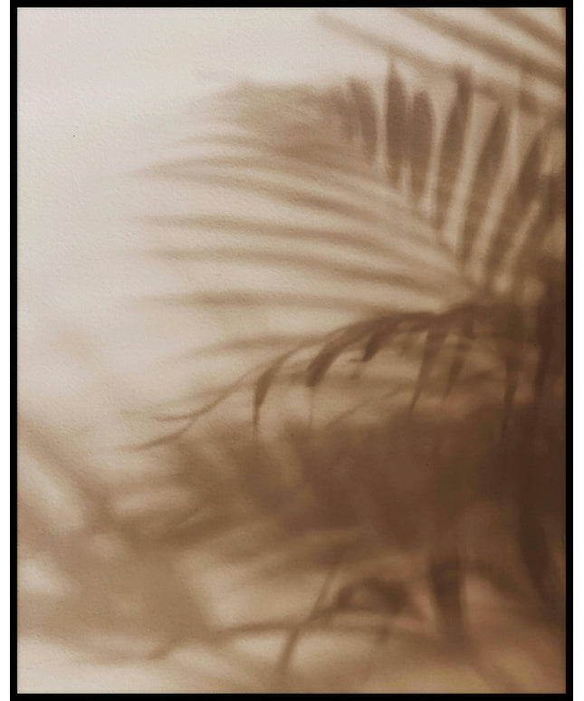 Ein Poster vom Schatten einzelner Palmenblätter auf einer beigefarbenen Häuserfassade.