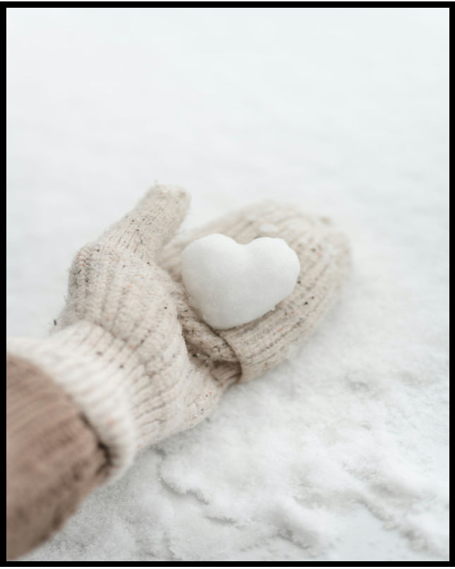 Ein Poster von einer behandschuhten Hand, die ein kleines Herz aus Schnee hält.