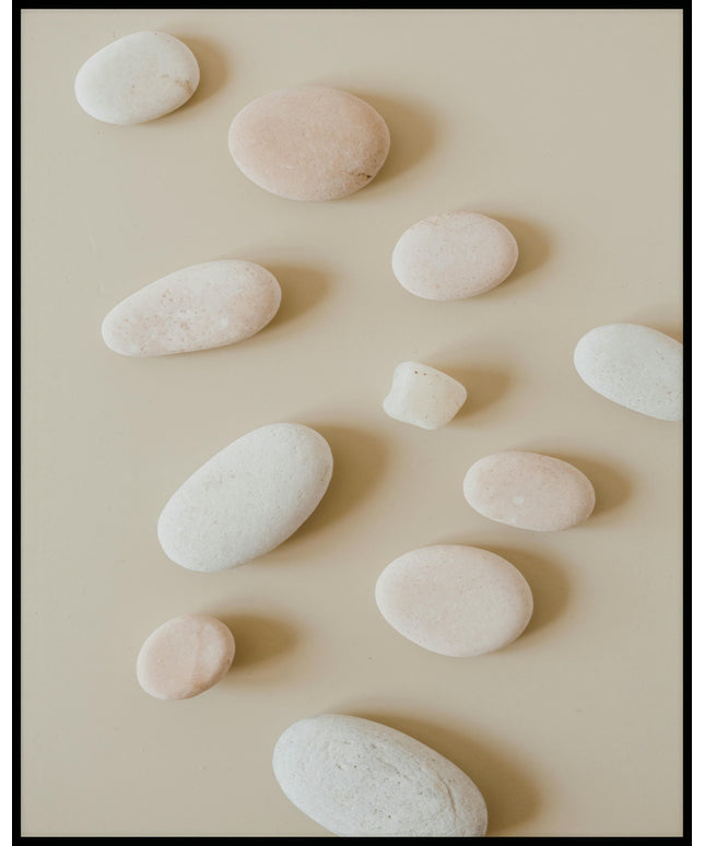 Ein Poster von mehreren runden, weißen Steinen auf beigefarbenem Untergrund.