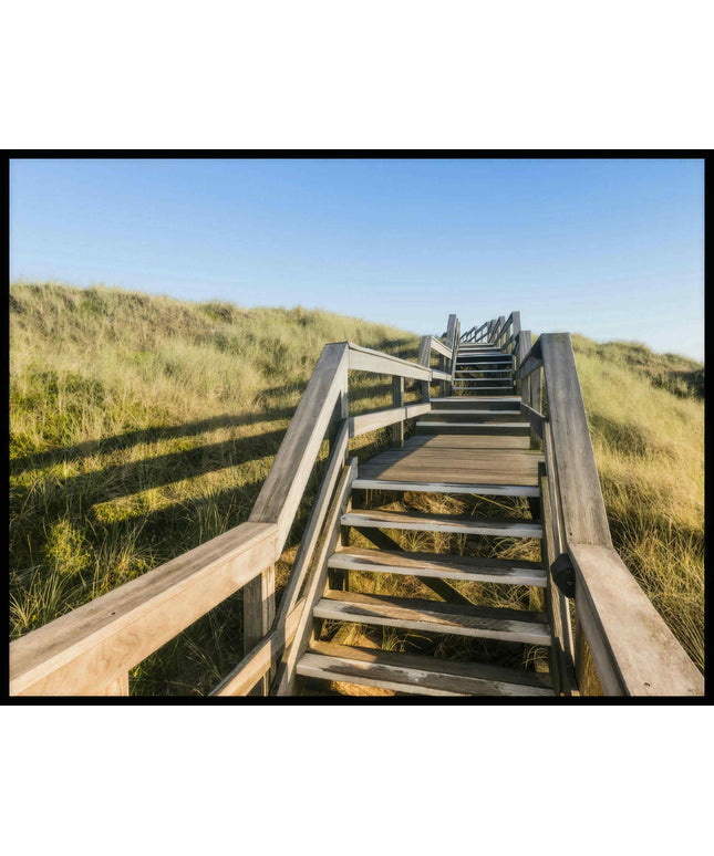Ein Poster von einer Holztreppe die über Dünen am Strand führt.
