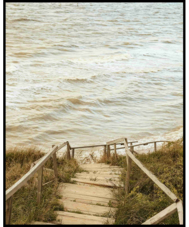 Ein Poster von einer Holztreppe die durch Dünen runter zum Strand führt.