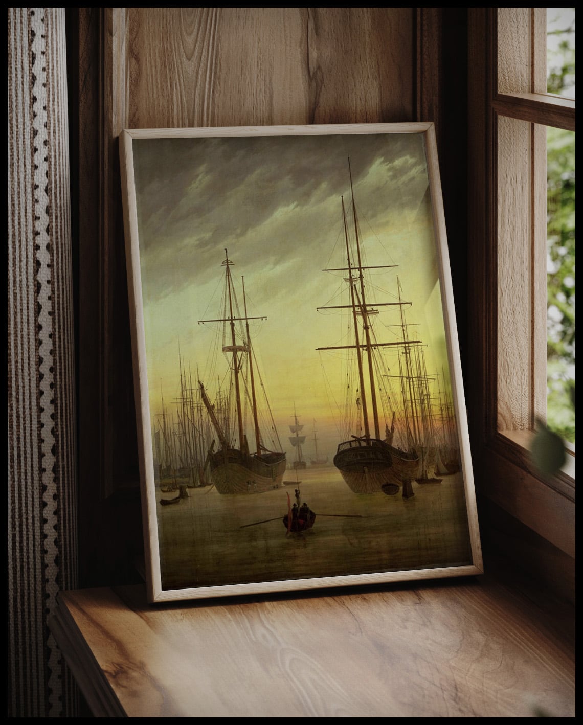 Ein gerahmter Kunstdruck von Schiffen in einem Hafen bei Sonnenuntergang, vor einem Fenster an die Wand angelehnt