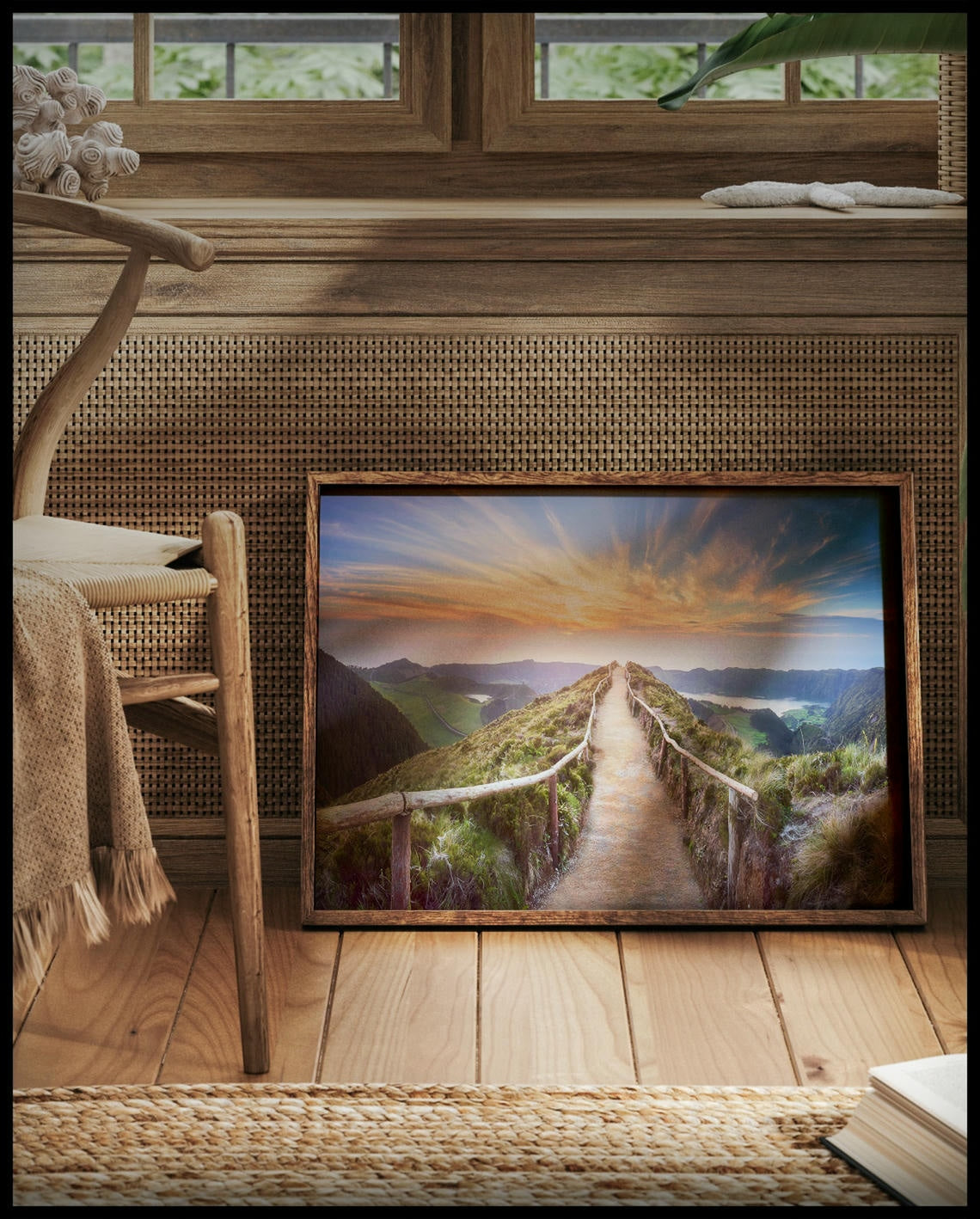 Ein gerahmtes Poster von einem Wanderweg auf den Azoren bei Sonnenaufgang, vor einem Fenster an die Wand angelehnt