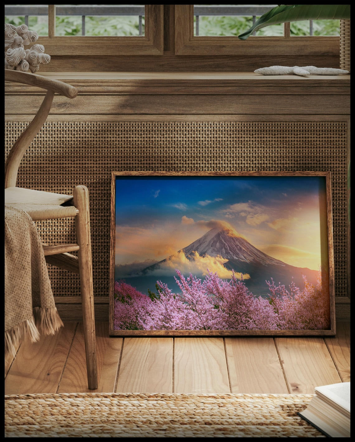 Ein gerahmtes Poster von einem blühenden Kirschbaumfeld vor dem Berg Fuji, vor einem Fenster an die Wand angelehnt