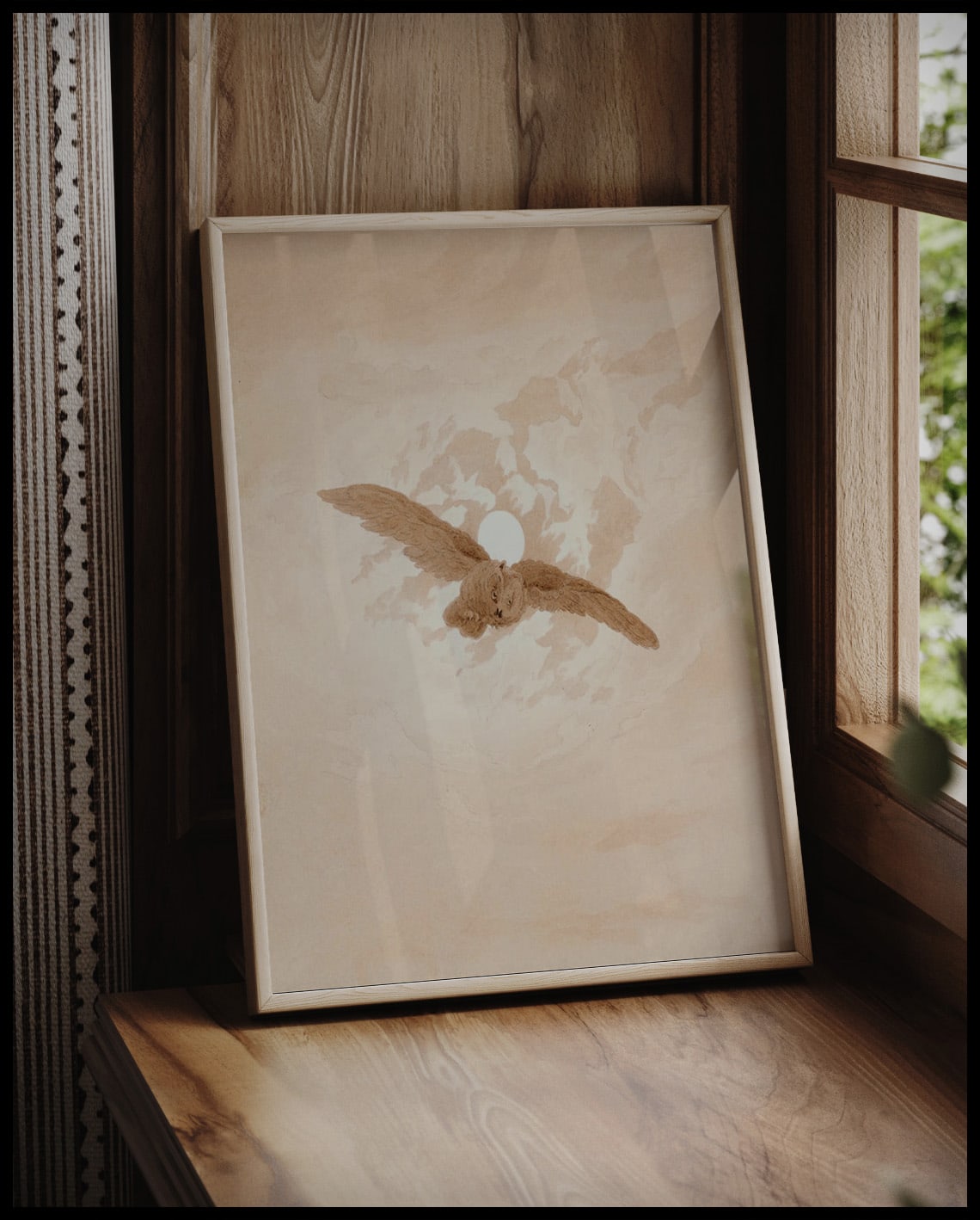 Ein gerahmter Kunstdruck einer fliegenden Eule vor einem Mondhimmel, vor einem Fenster an die Wand angelehnt