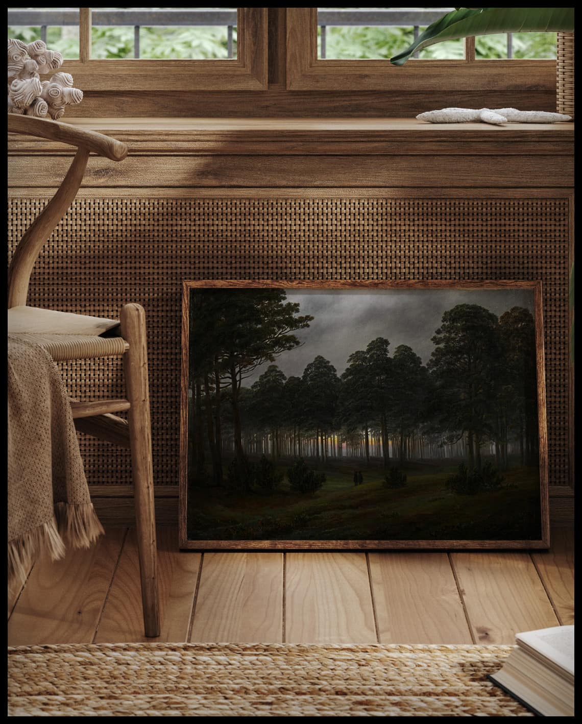 Ein Kunstdruck von einer Lichtung im Wald am Abend, vor einem Fenster an die Wand angelehnt
