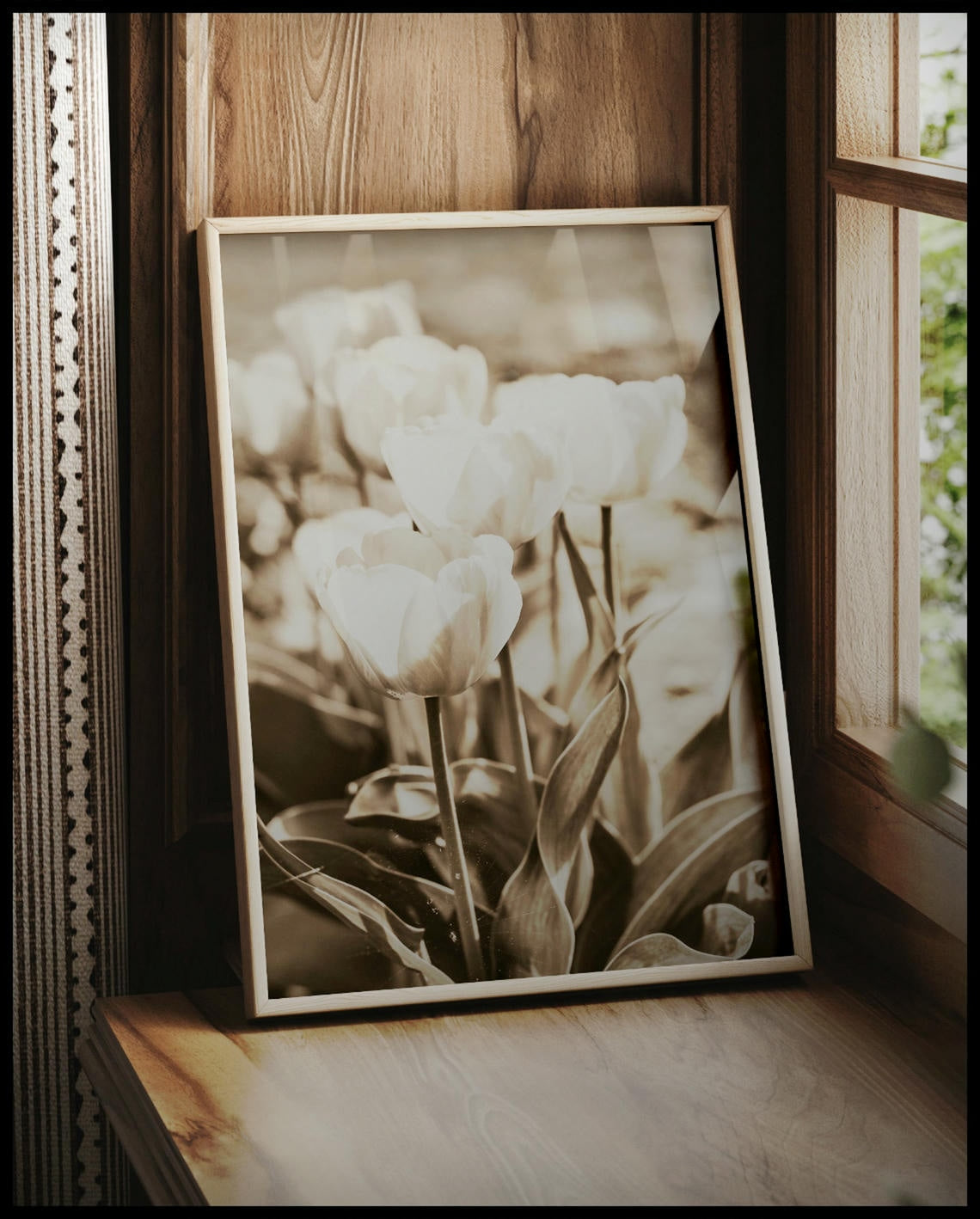 Ein gerahmtes Poster von mehreren Tulpen mit Sepiafilter, vor einem Fenster an die Wand angelehnt