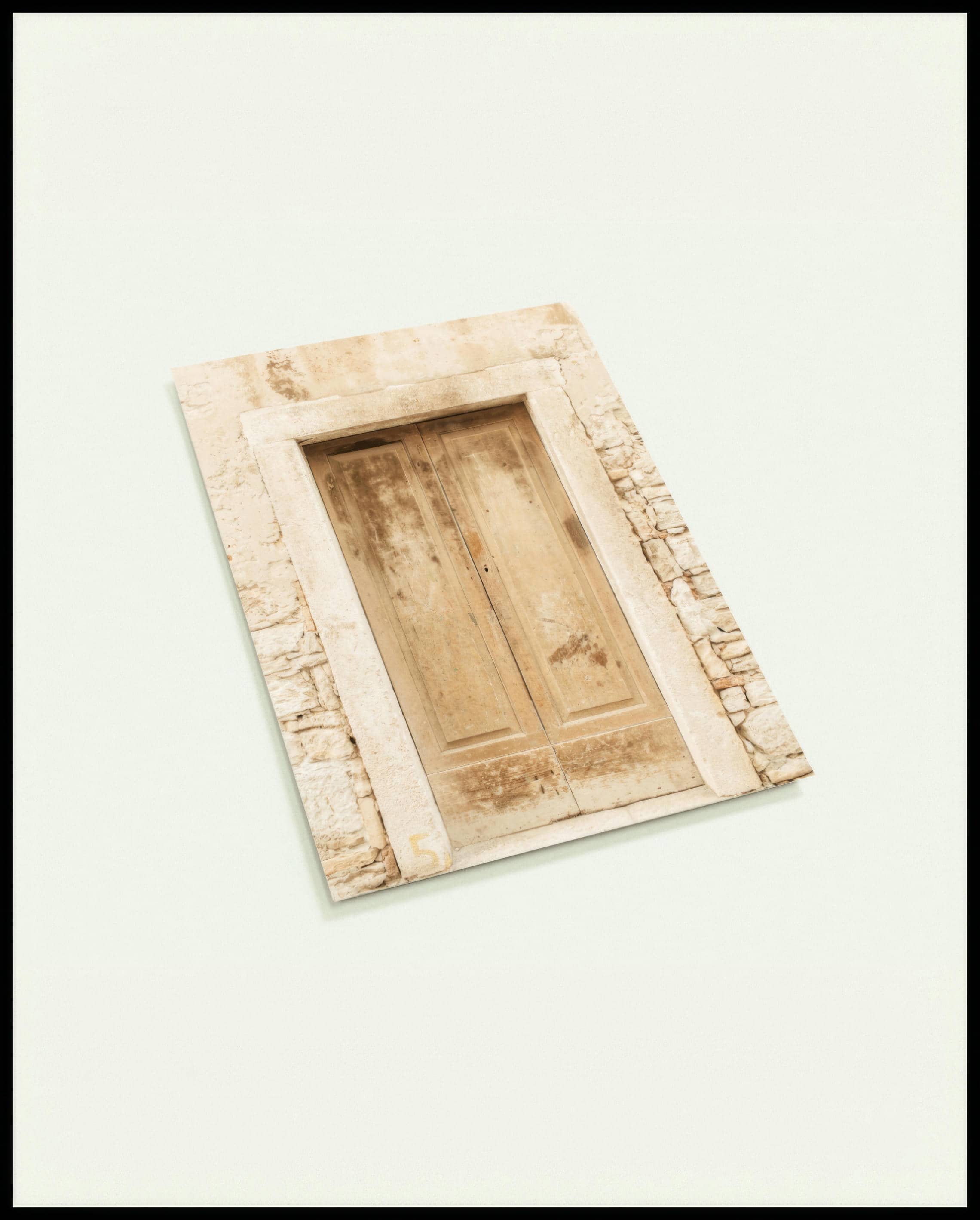 Eine Postkarte von einer alten, verwitterten Holztür in einer Steinmauer.